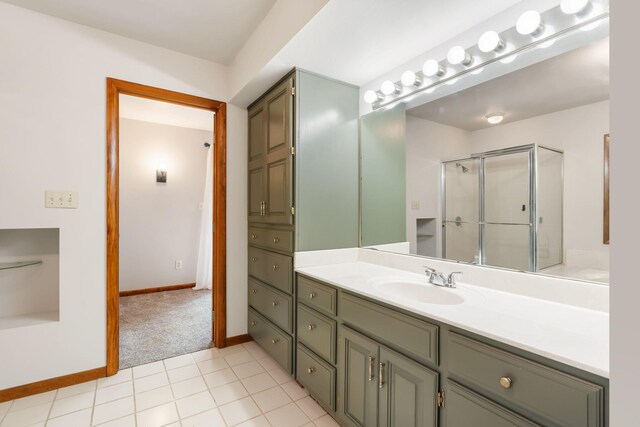 full bath featuring a shower stall, vanity, and baseboards