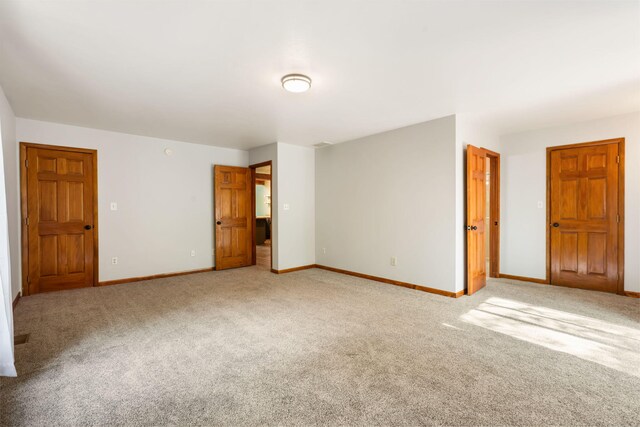 spare room with light carpet and baseboards