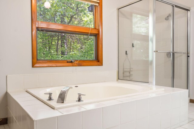 bathroom featuring a stall shower and a garden tub