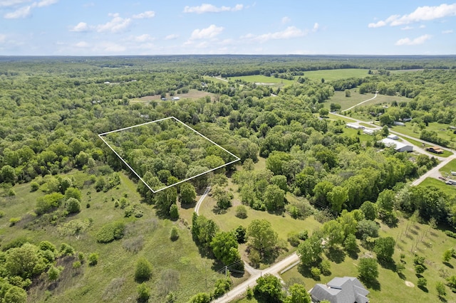aerial view of property's location with property boundaries highlighted and a heavily wooded area
