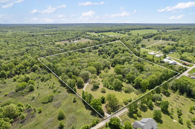 aerial view of property and surrounding area featuring property boundaries highlighted and a forest