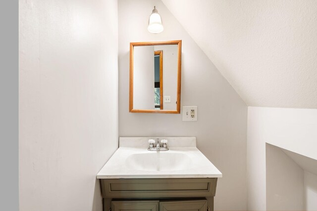 bathroom featuring vaulted ceiling and vanity