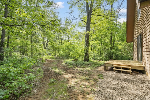 view of yard featuring a deck and a forest view