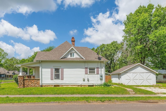 901 W Poplar St, Springfield, MO 65802 - view of home's exterior featuring an outbuilding, a chimney, a lawn, a detached garage, and roof with shingles