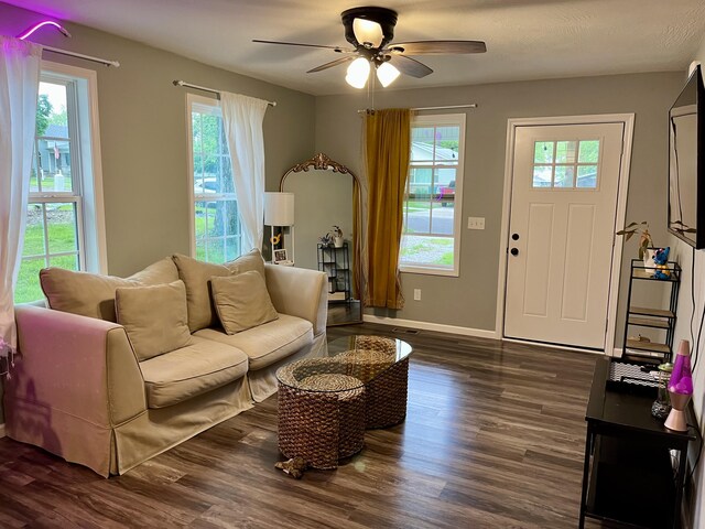 living area featuring a ceiling fan, dark wood-style floors, and baseboards