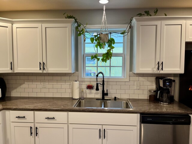 kitchen featuring dishwasher, a sink, white cabinetry, and dark countertops