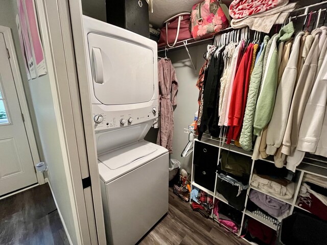 laundry area featuring stacked washer / dryer and wood finished floors