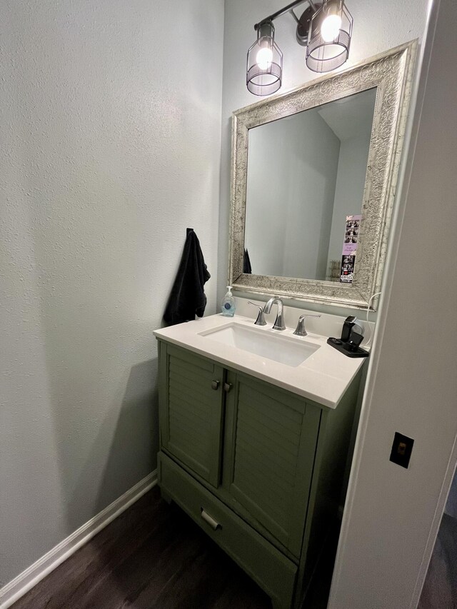 bathroom featuring vanity, wood finished floors, and baseboards