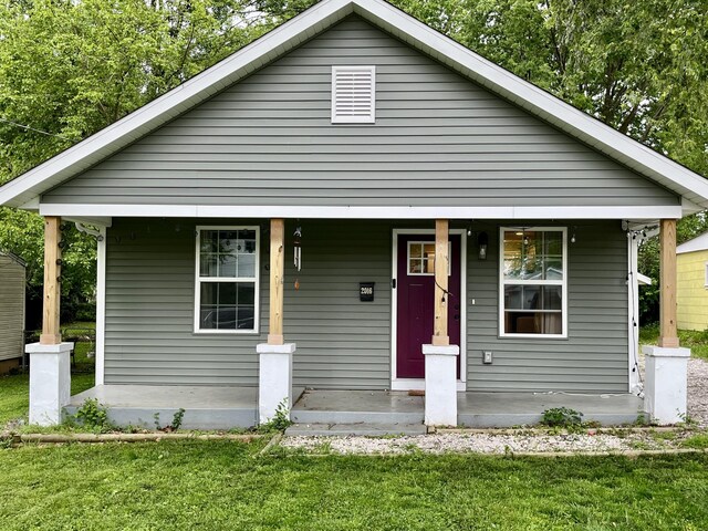 view of front of house with a porch and a front lawn