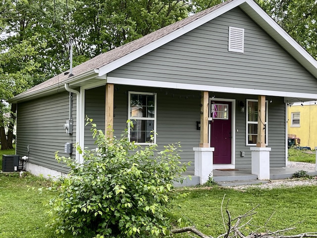 view of front facade with a porch, a front lawn, central air condition unit, and a shingled roof