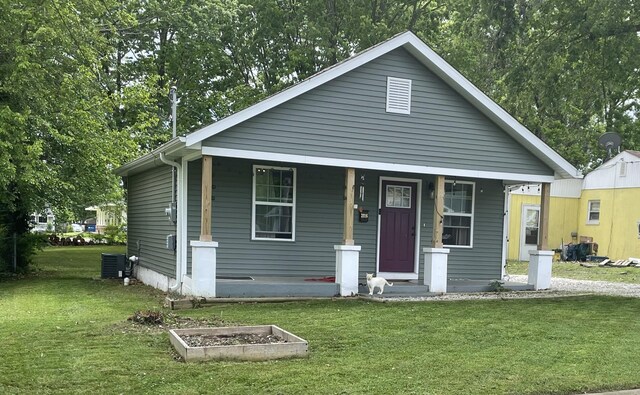 view of front of property with covered porch, central AC unit, and a front lawn