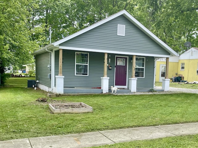 view of front of house featuring covered porch, a front yard, and cooling unit