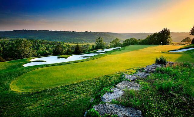 surrounding community featuring golf course view and a yard