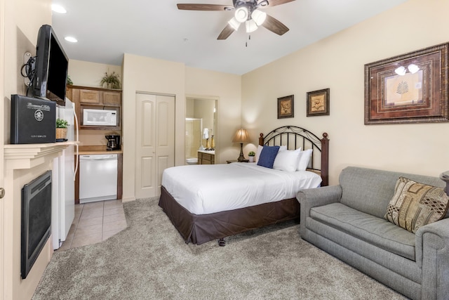 bedroom featuring light tile patterned flooring, a closet, a fireplace, connected bathroom, and a ceiling fan