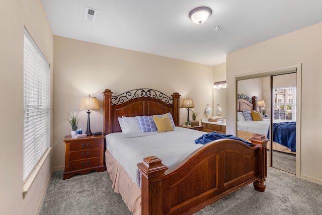 bedroom with light carpet, baseboards, and a closet