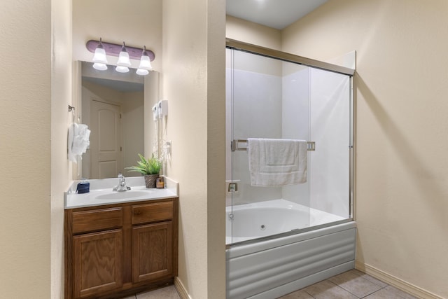 full bath with combined bath / shower with glass door, tile patterned floors, vanity, and baseboards