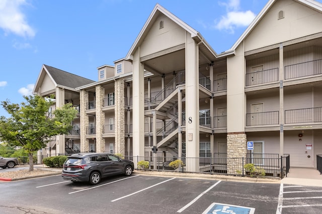 view of apartment building / complex featuring uncovered parking