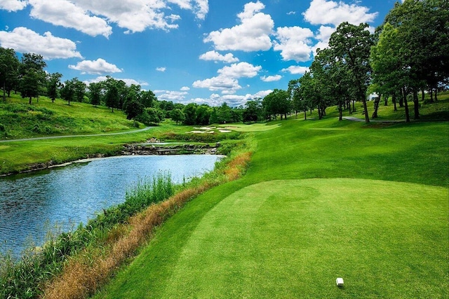 view of property's community featuring a water view, view of golf course, and view of scattered trees
