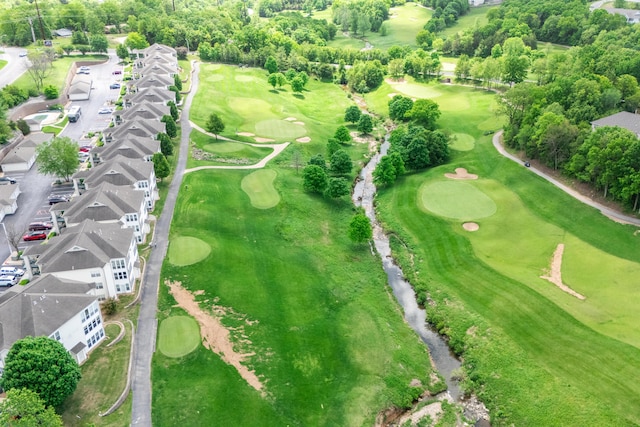 aerial perspective of suburban area featuring a local golf course and a tree filled landscape