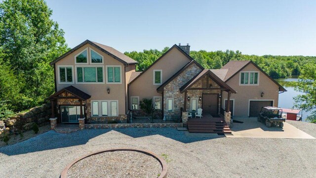 3701 S 1500th Rd, Rich Hill, MO 64779 - view of front facade featuring stone siding, driveway, stucco siding, and a chimney