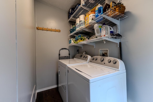 laundry area featuring washer and clothes dryer, dark wood-style floors, and baseboards