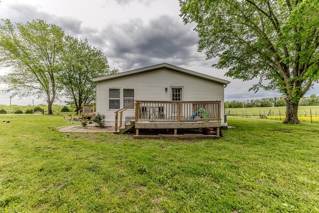 rear view of property with a deck and a yard