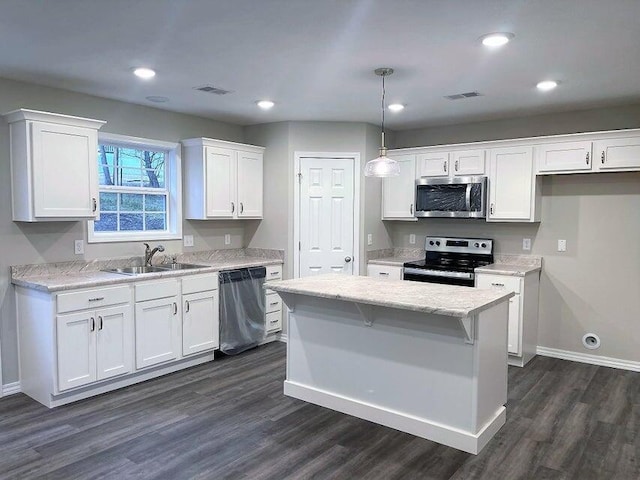 335 Mccann Rd, Powersite, MO 65731 - kitchen with stainless steel appliances, a sink, white cabinetry, dark wood-style flooring, and a kitchen island