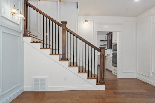 stairway with wood finished floors and baseboards