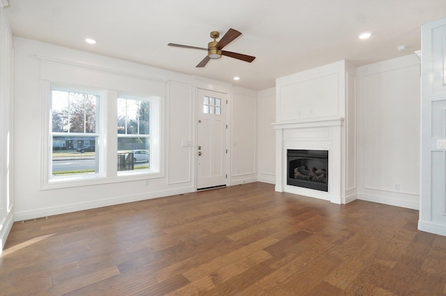 unfurnished living room featuring a ceiling fan, a fireplace, wood finished floors, recessed lighting, and baseboards