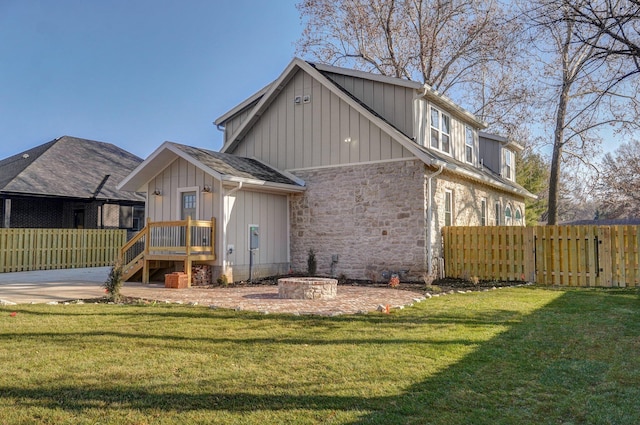 back of house featuring board and batten siding and stone siding