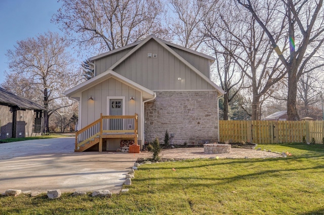 view of front of house with stone siding and an outdoor fire pit