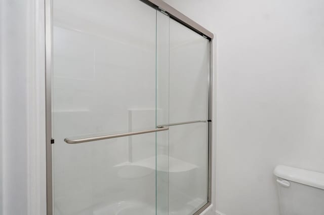 bathroom with toilet and a shower stall