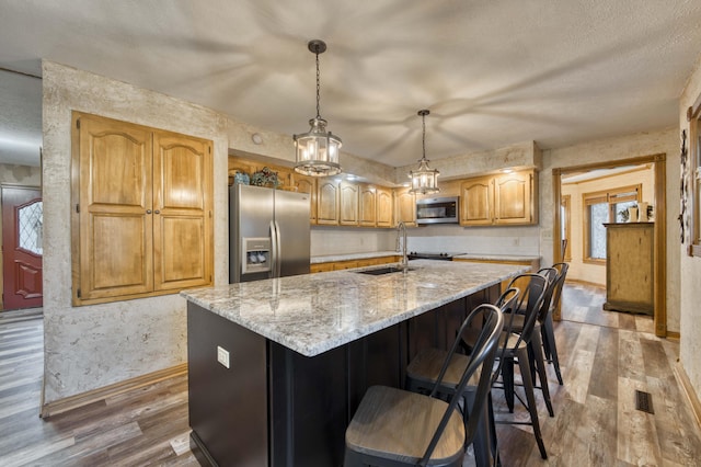 5425 S Westwood Ave, Springfield, MO 65810 - kitchen featuring appliances with stainless steel finishes, a sink, baseboards, wood finished floors, and a textured wall