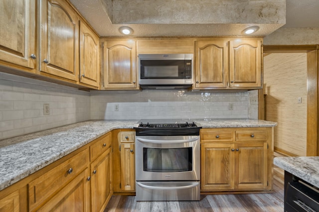 5425 S Westwood Ave, Springfield, MO 65810 - kitchen featuring stainless steel appliances, dark wood-type flooring, backsplash, and light stone counters