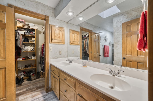 5425 S Westwood Ave, Springfield, MO 65810 - full bathroom with wood finished floors, a skylight, double vanity, and a walk in closet