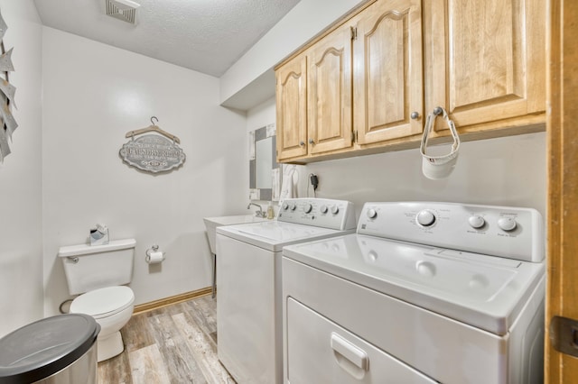 5425 S Westwood Ave, Springfield, MO 65810 - laundry room with washing machine and dryer, light wood-style flooring, a textured ceiling, and baseboards