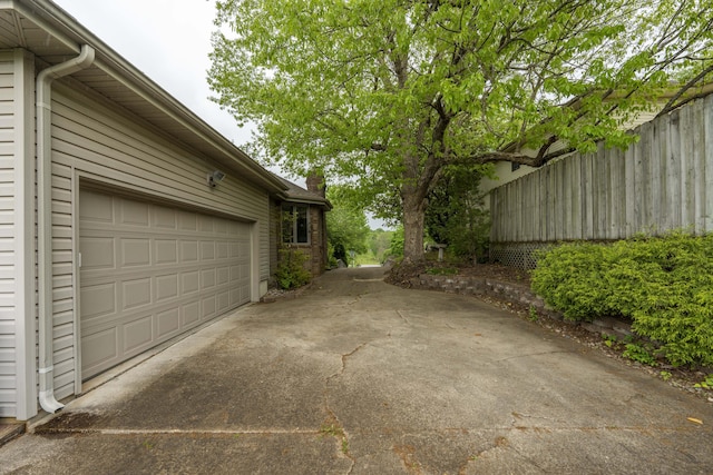 5425 S Westwood Ave, Springfield, MO 65810 - view of side of property featuring driveway, fence, a chimney, and a garage
