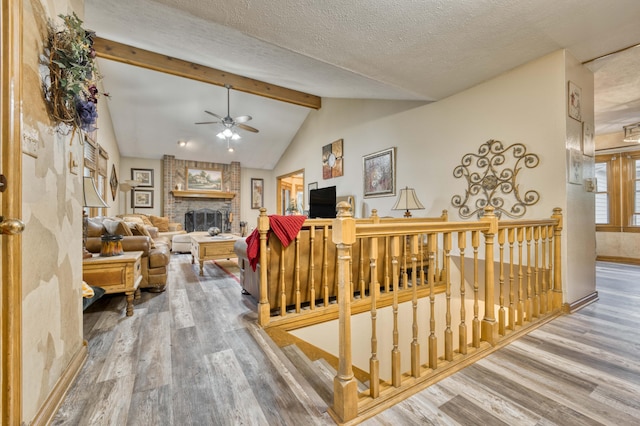5425 S Westwood Ave, Springfield, MO 65810 - living room featuring wood finished floors, a ceiling fan, a brick fireplace, baseboards, and a textured ceiling