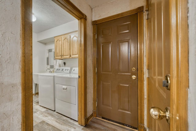 5425 S Westwood Ave, Springfield, MO 65810 - laundry area with cabinet space, washing machine and dryer, light wood-type flooring, and a textured ceiling