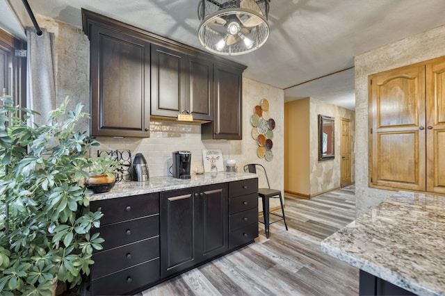 5425 S Westwood Ave, Springfield, MO 65810 - bar area with light wood-style flooring, backsplash, and baseboards