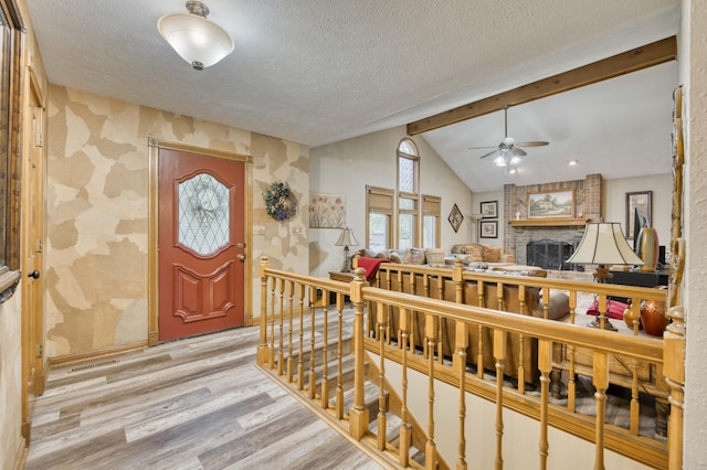 5425 S Westwood Ave, Springfield, MO 65810 - entryway featuring wallpapered walls, light wood-style flooring, ceiling fan, a brick fireplace, and a textured ceiling