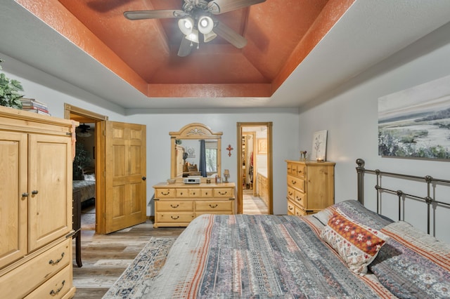 5425 S Westwood Ave, Springfield, MO 65810 - bedroom featuring a raised ceiling, light wood finished floors, connected bathroom, and a ceiling fan