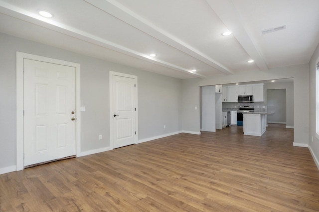 610 Chicago Ave, Marionville, MO 65705 - unfurnished living room with light wood finished floors, baseboards, beam ceiling, and recessed lighting