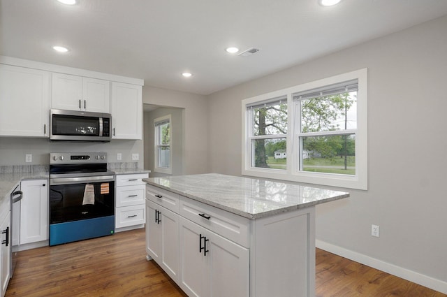 610 Chicago Ave, Marionville, MO 65705 - kitchen featuring stainless steel appliances, wood finished floors, recessed lighting, white cabinets, and light stone countertops