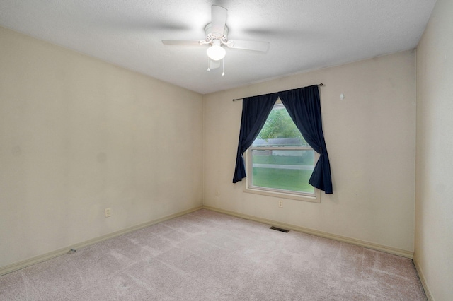 carpeted empty room with baseboards and ceiling fan