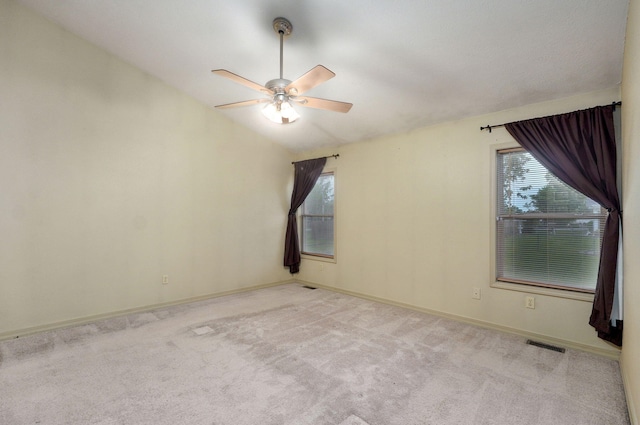 unfurnished room with a ceiling fan, plenty of natural light, light carpet, and vaulted ceiling