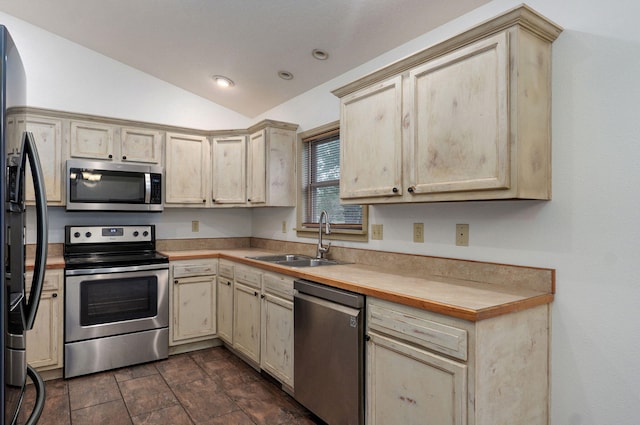 kitchen with stainless steel appliances, a sink, lofted ceiling, light countertops, and recessed lighting