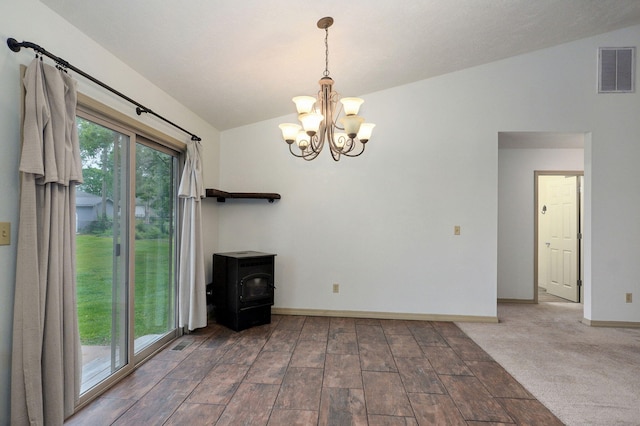 unfurnished living room featuring lofted ceiling, a wood stove, a chandelier, and baseboards