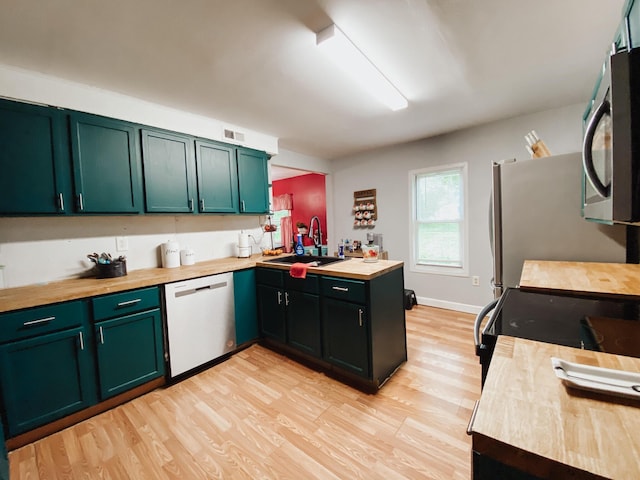 310 W Delta St, Aurora, MO 65605 - kitchen featuring dishwashing machine, a sink, wooden counters, stainless steel microwave, and light wood-type flooring