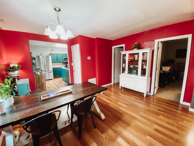 310 W Delta St, Aurora, MO 65605 - dining area featuring a chandelier and light wood-style floors